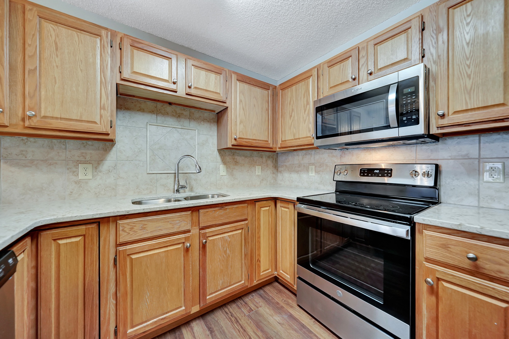 a kitchen with wooden cabinets and a stove and a microwave
